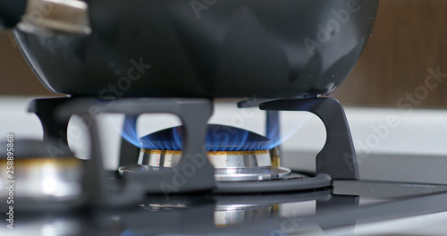 Stove top burner igniting into a blue cooking