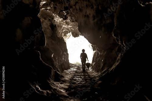 Sagoma di donna con ombrello nella grotta