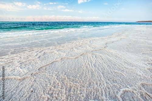 Obraz na płótnie .incredibly beautiful seaside of the dead sea with blue water and white crystals of salt near.selective focus w salonie