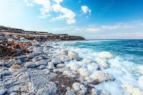 .incredibly beautiful seaside of the dead sea with blue water and white crystals of salt near.selective focus photo