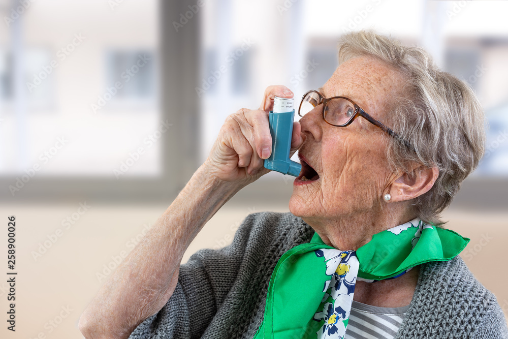 Close-up of senior woman using asthma inhaler. - obrazy, fototapety, plakaty 