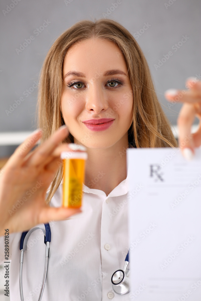 Beautiful smiling female doctor hold prescription Beautiful smiling female doctor hold prescription