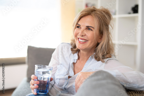 Foto Positiv lachende Frau zuahause auf der Couch