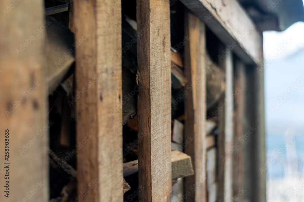Firewood harvested for the winter behind a wooden fence