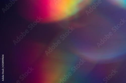 Purple bokeh dark spots. Faded colorful backdrop. Dark lens flare background.