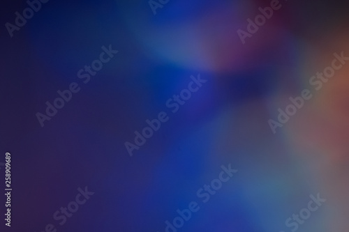 Blurry blue lights on dark background. Defocused lens flare glow. Abstract design.