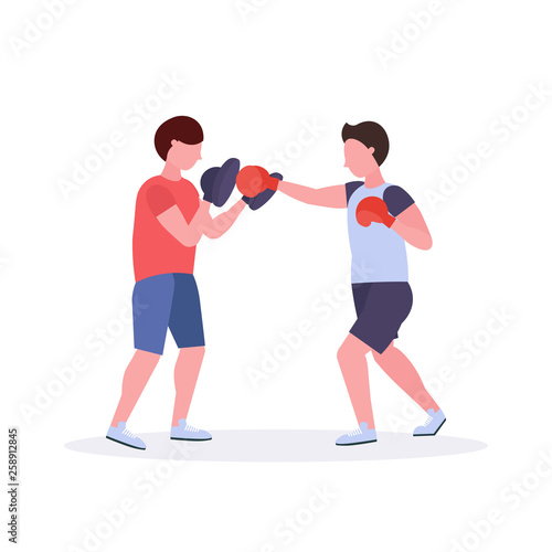 two men boxers exercising thai boxing in red gloves couple fighters practicing at the fight club healthy lifestyle concept flat white background