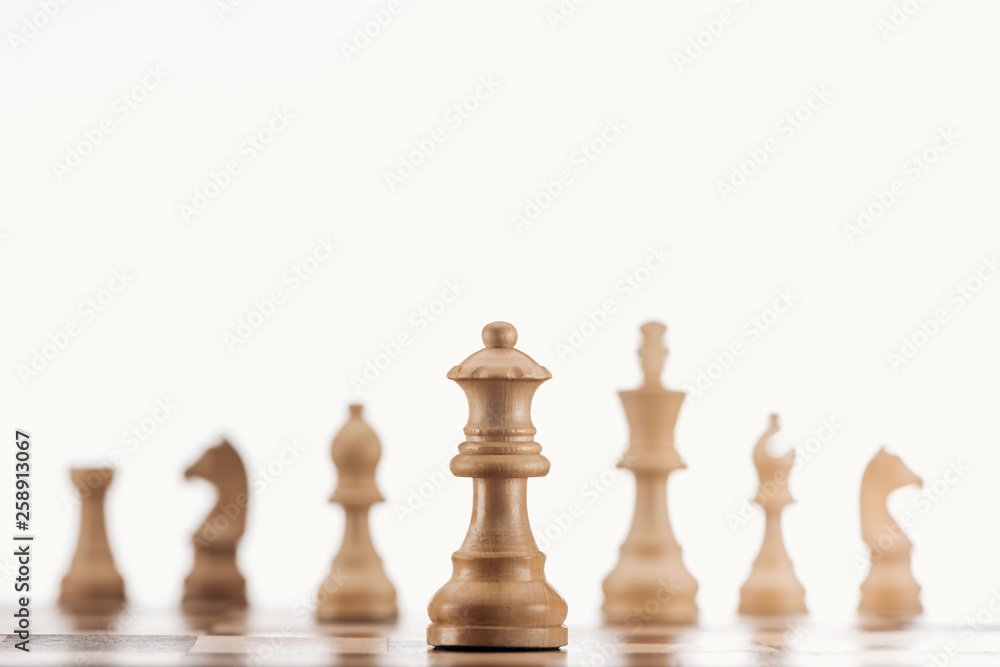 selective focus of beige wooden queen on chessboard isolated on white selective focus of beige wooden queen on chessboard isolated on white