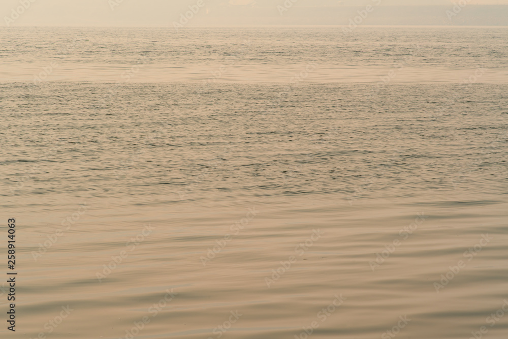 Wavy water surface with ripples and white sky background.