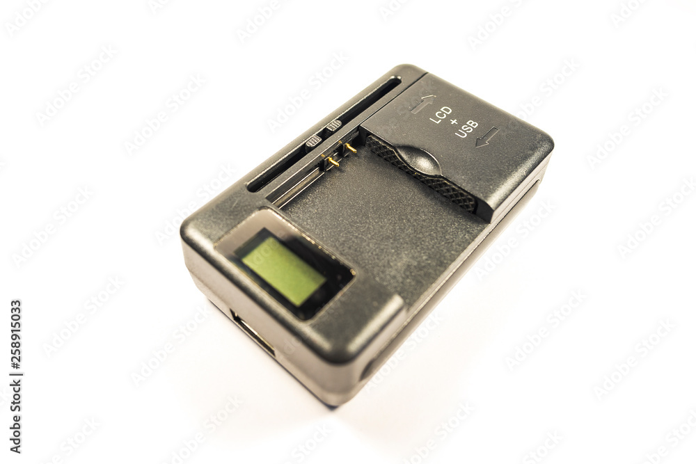 Universal charger for lithium-ion battery made of black plastic with adjustable contacts and usb output on a white background Universal charger for lithium-ion battery made of black plastic with adjustable contacts and usb output on a white background