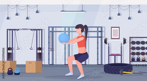 sporty woman doing squat exercises with fitness ball girl training aerobic workout healthy lifestyle concept modern gym interior flat horizontal