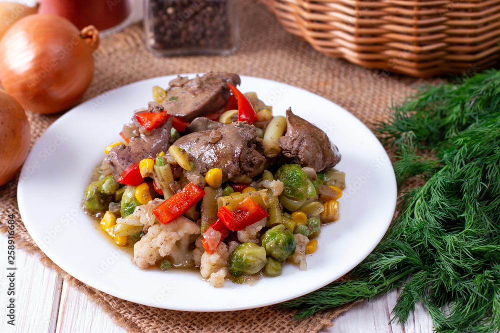 Chicken liver with vegetables in a plate on a table Chicken liver with vegetables in a plate on a table
