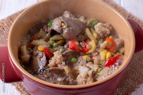Chicken liver stew with vegetables in a pan on a table