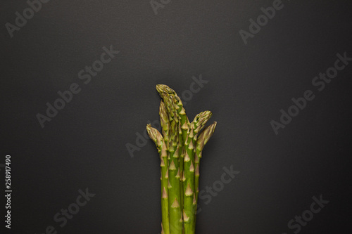 Top view of fresh green asparagus on black surface