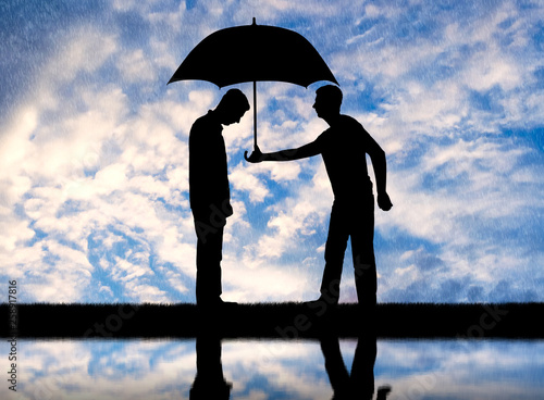 Altruist man gives his umbrella to another sad man standing in the rain