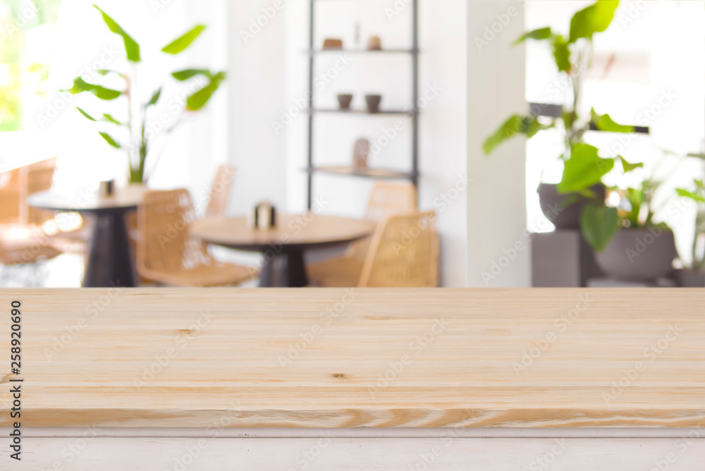 Wood table top on defocused restaurant or coffee shop background