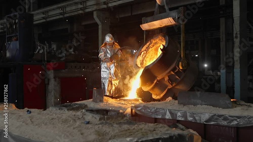 Man working with liquid metal in factory. Metal factory sparks