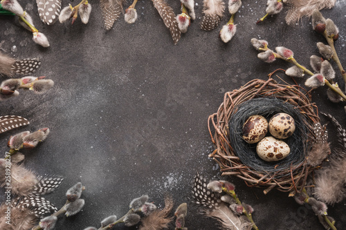 Quail easter eggs in nest, and spring willow on vintage table.