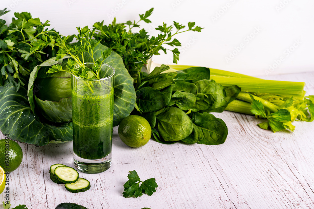 Detox cucumber smoothie with greenery in glass at wooden white background. Detox cucumber smoothie with greenery in glass at wooden white background.