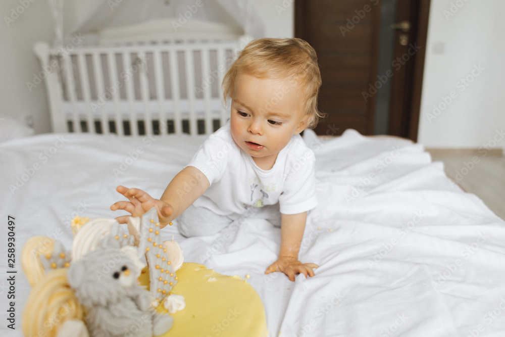 Fototapeta premium The child stretches to sweets from the cake