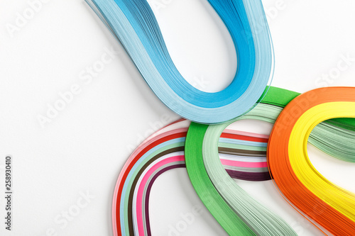 top view of wavy rainbow paper lines on grey background with copy space