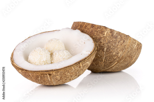 Group of two halves of fresh bio coconut with three small cocoa balls isolated on white background