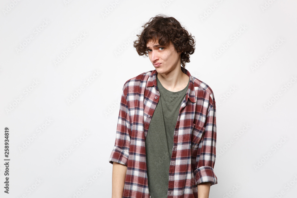 Portrait of puzzled disgusted perplexed young man in casual clothes looking camera, blowing lips isolated on white background in studio. People sincere emotions, lifestyle concept. Mock up copy space. Portrait of puzzled disgusted perplexed young man in casual clothes looking camera, blowing lips isolated on white background in studio. People sincere emotions, lifestyle concept. Mock up copy space.