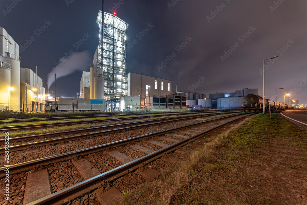 Night view of an industrial zone with the rail road transporting in and out raw material