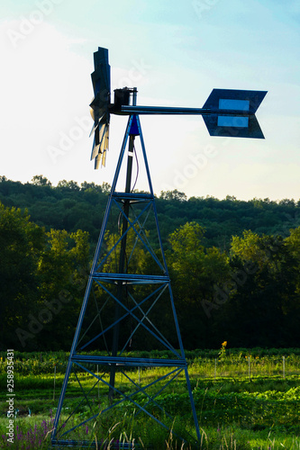 Sharon, Conecticut, USA A windmill and weathervane at a farm at sunset. photo