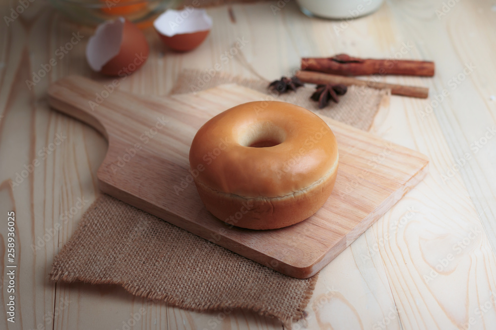 Home made donut on wood cut board with bakery ingredients on wooden table select focus shallow depth of field