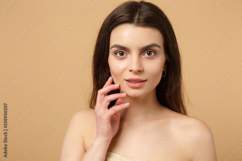 Close up brunette half naked woman 20s with perfect skin, nude make up isolated on beige pastel wall background, studio portrait. Skin care healthcare cosmetic procedures concept. Mock up copy space.