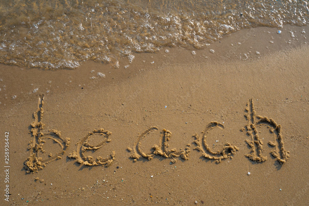 Fototapeta premium Vacation on the sand beach concept. Beach words written into the sand on the beach at Rayong, Thailand.