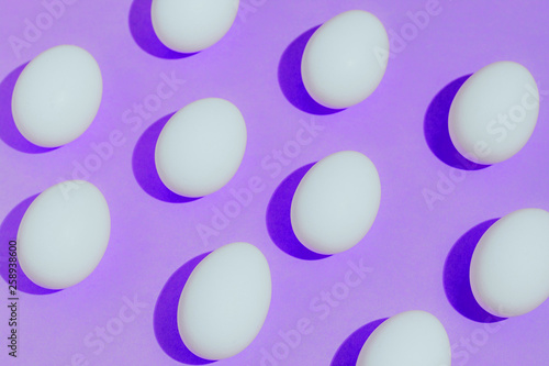 White chicken eggs  with empty space  on a pink purple background. Abstract image