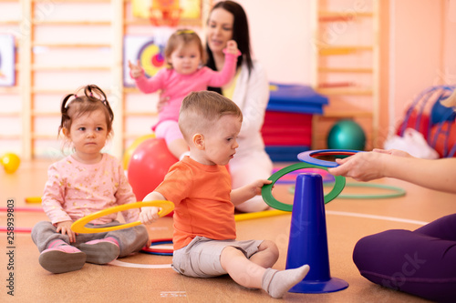 Nursery babies group doing sport in gym