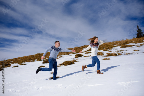 People having fun and running in mountains on the background of high snow-capped peaks