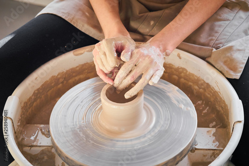 Woman making ceramic pottery on wheel, creation of ceramic ware. Concept of women's work, craft