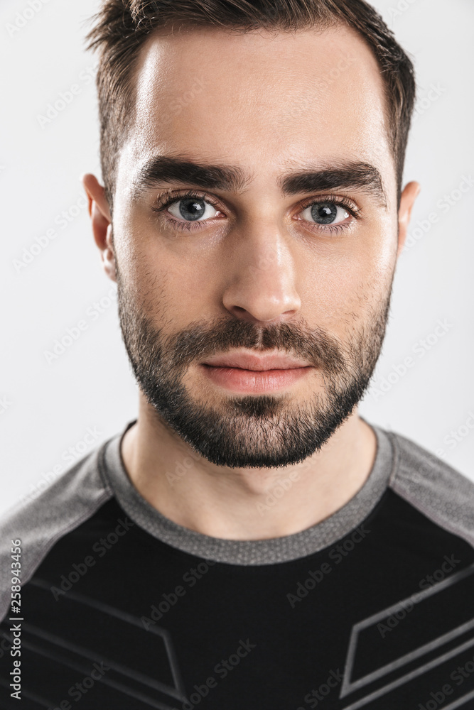 Fototapeta premium Handsome young sports fitness man posing isolate over white wall background.