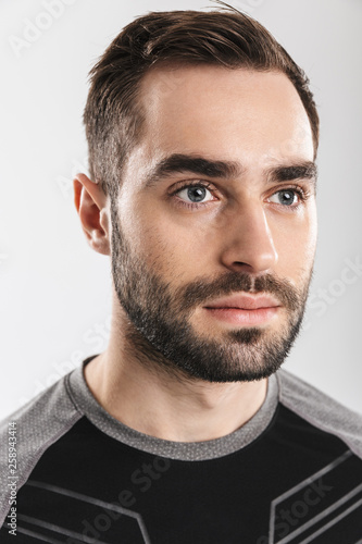 Handsome young sports fitness man posing isolate over white wall background.