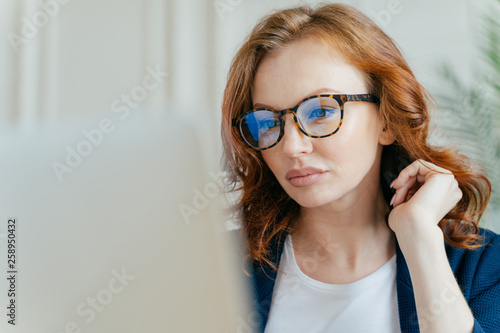 Valokuva Close up shot of focused female worker completes successful project, makes remot