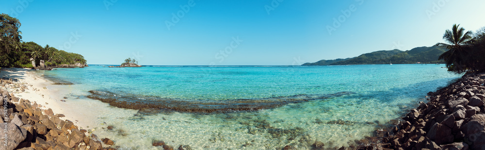 A stunning wide panoramic large format photograph of The stunning Anse royal beach in the seychelles, island of mahe. Paradise and beautiful blue sky.