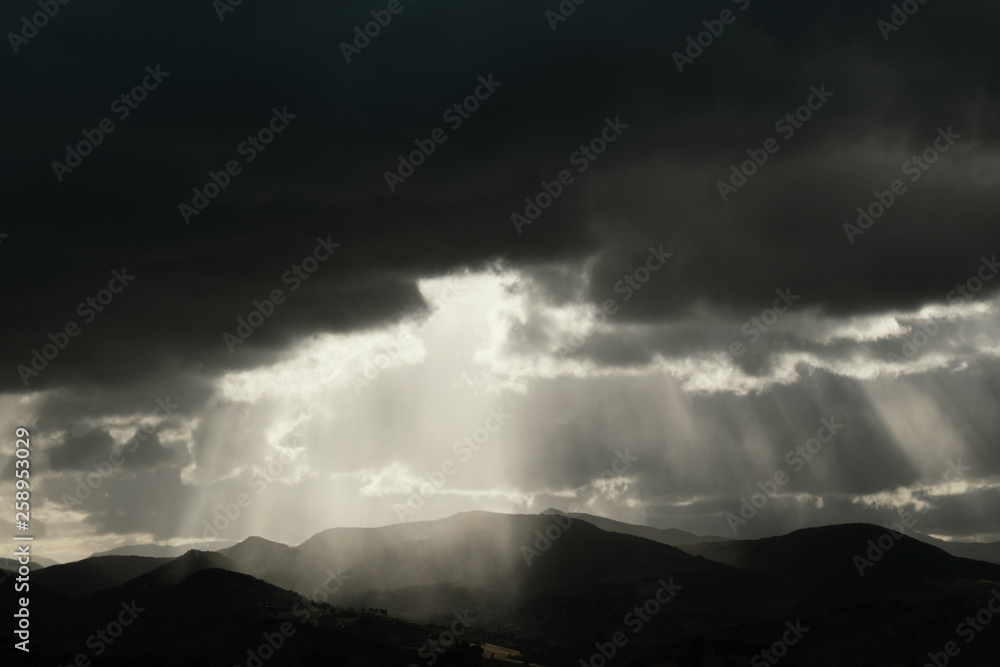 Beautiful landscape at sunset, sunbeams in the dramatic sky	