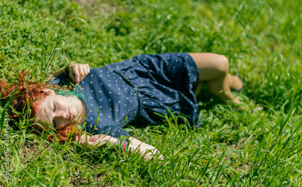 Beautiful redhead girl lay on grass. Beautiful redhead girl lay on grass.