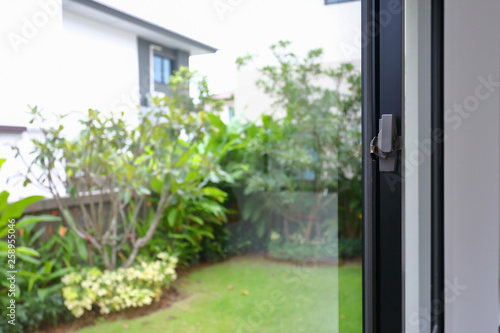 security lock on glass window with green garden outside view of home