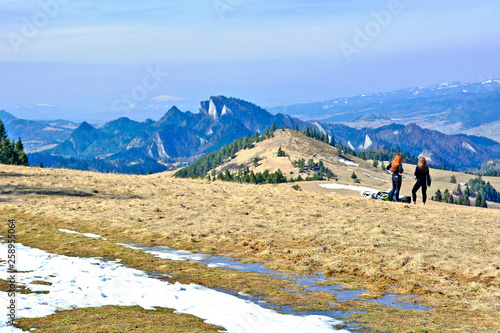Two young tourist women looking at amazing mountains in early spring, travel concept, Pieniny mountains, Szczawnica, Poland