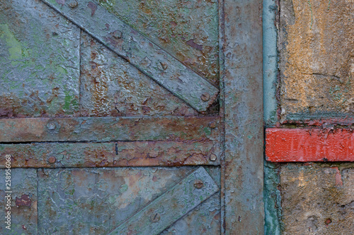 Details of old rusty gate with diagonal slats.