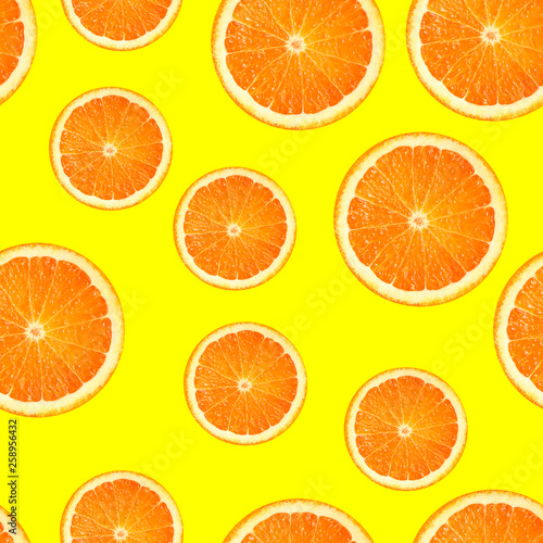 Slices of orange or tangerine isolated on yellow background. Flat lay, top view. Summer fruit composition. seamless pattern