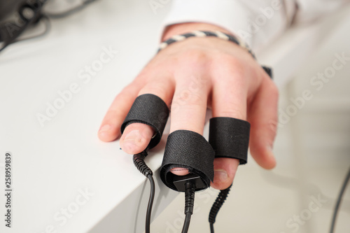 man s hands on which polygraph sensors are worn.