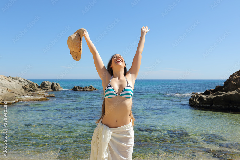 Happy tourist raising arms celebrating vacation on the beach Happy tourist raising arms celebrating vacation on the beach
