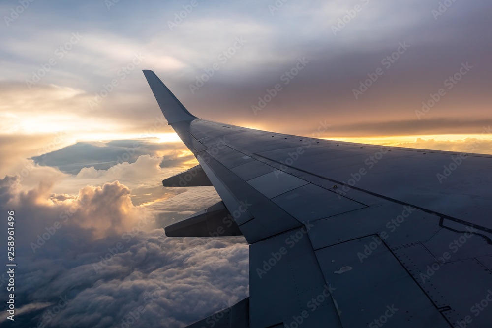 wing of an airplane flying above clouds wing of an airplane flying above clouds