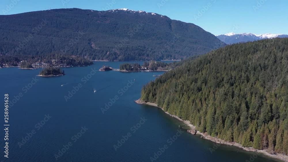 Aerial view over Burrard Inlet, ocean and island with boat and mountains in beautiful British Columbia. Canada. 4K. Aerial view over Burrard Inlet, ocean and island with boat and mountains in beautiful British Columbia. Canada. 4K.